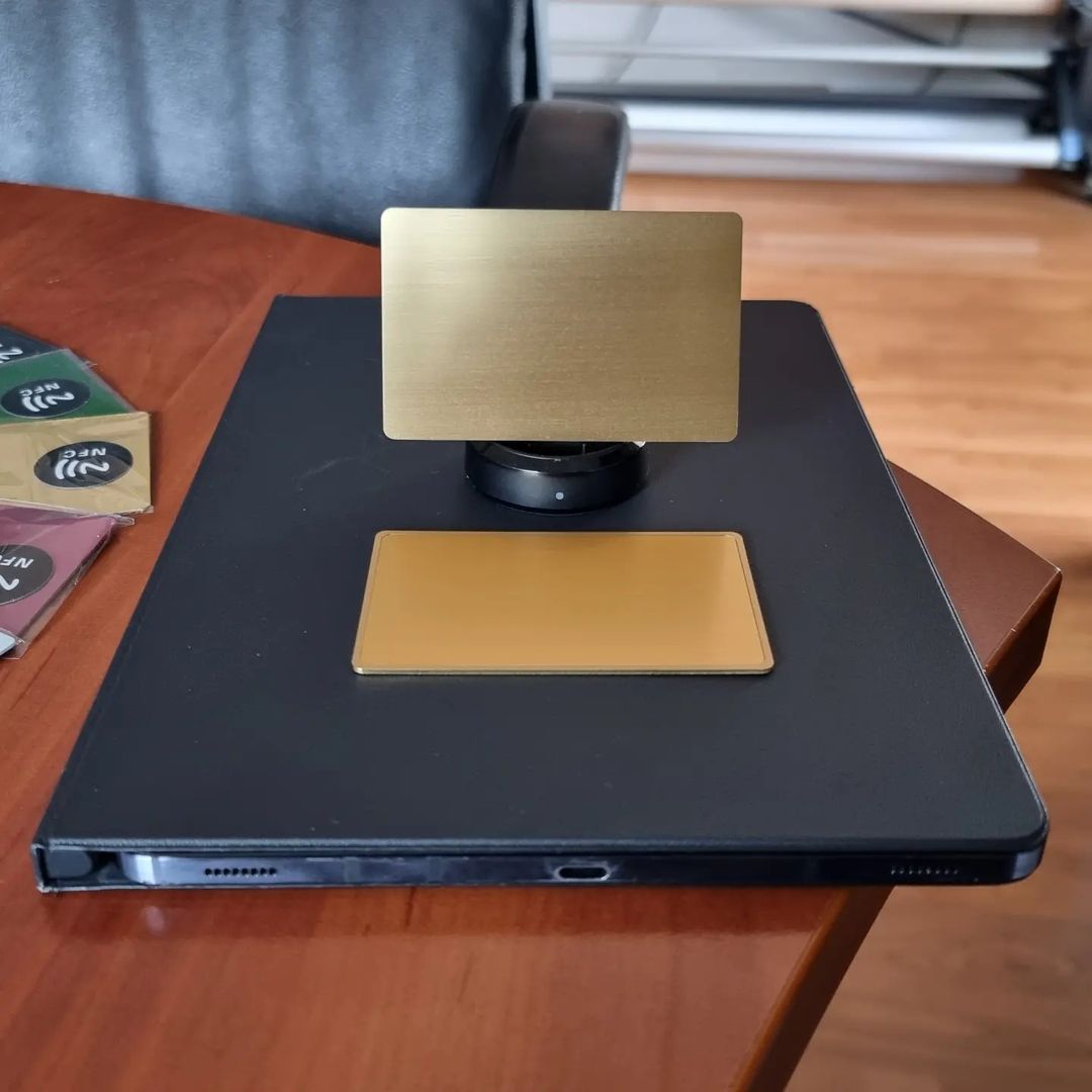 Zlatna NFC kartica pored laptopa